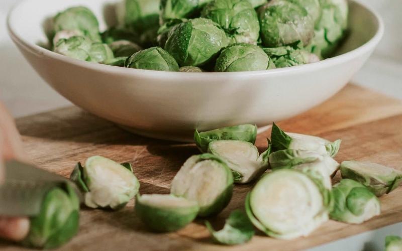 a person cutting brussel sprouts